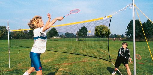 Freizeit-Badmintonnetz mir 2 Spielerinnen auf Rasen